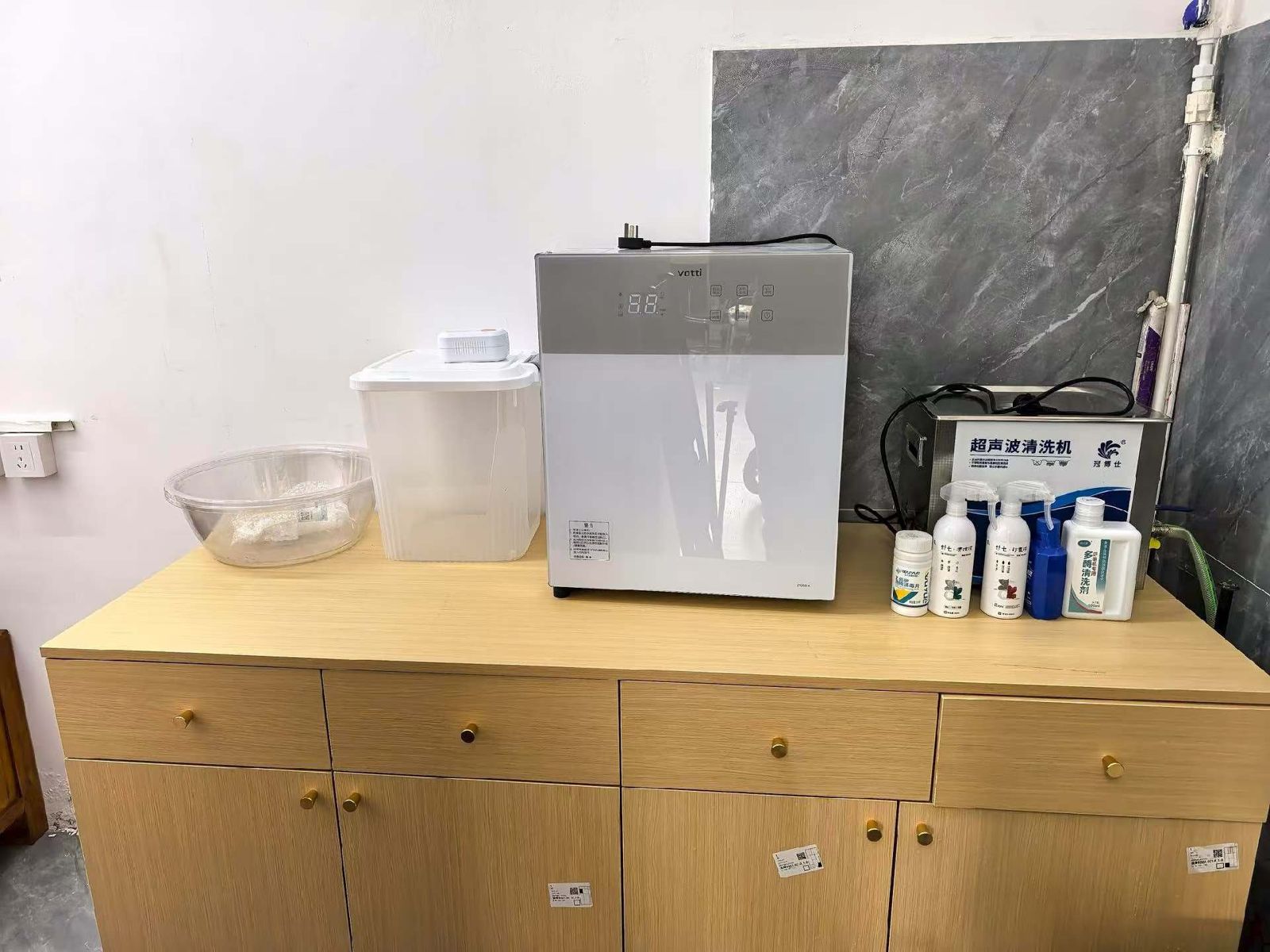 店内面罩清洗消毒区,柜面上有消毒柜、超声波清洗机与清洗用品