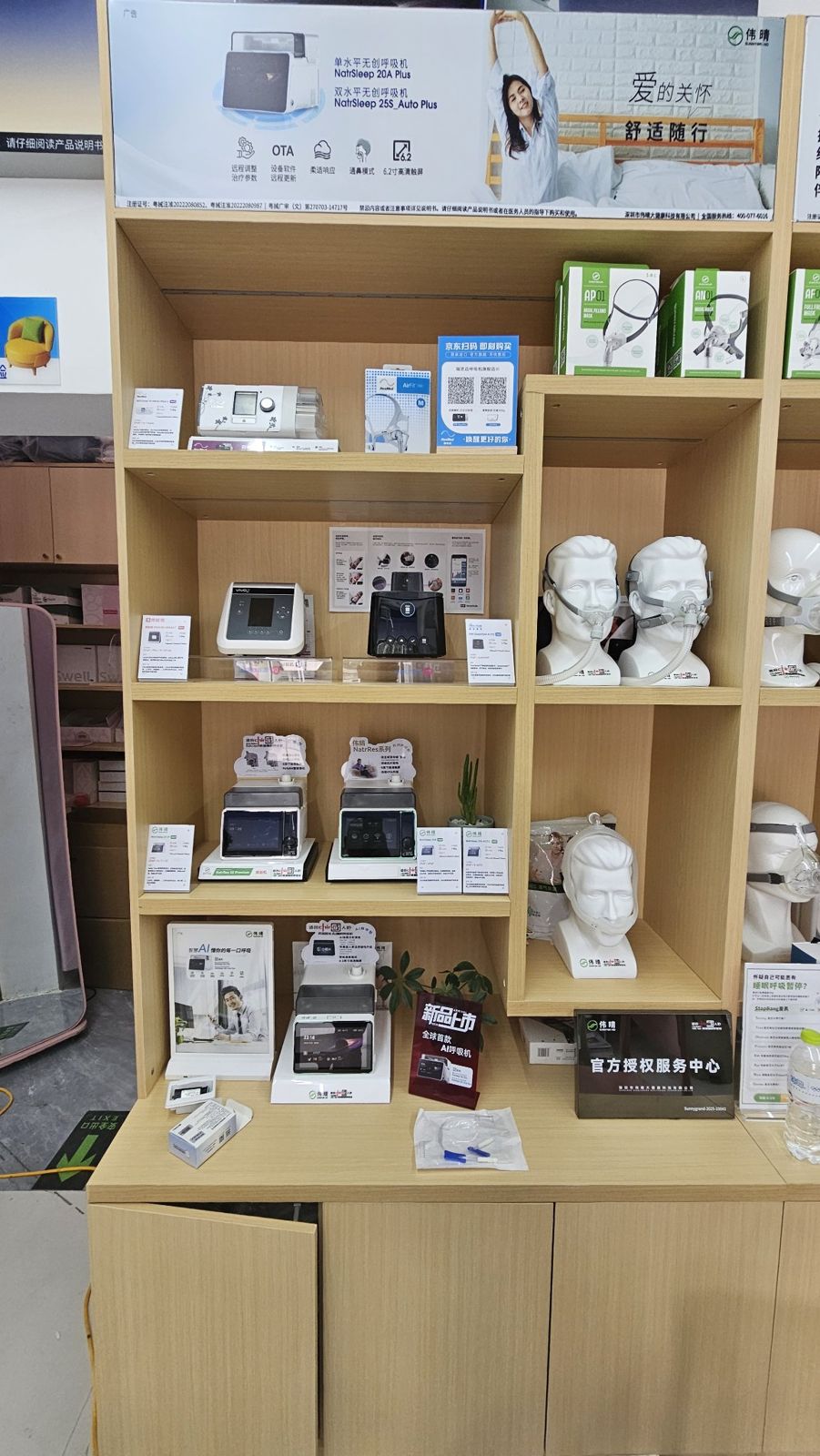 店内呼吸机与面罩展示墙,模特头佩戴面罩,下方有伟晴官方授权服务中心牌