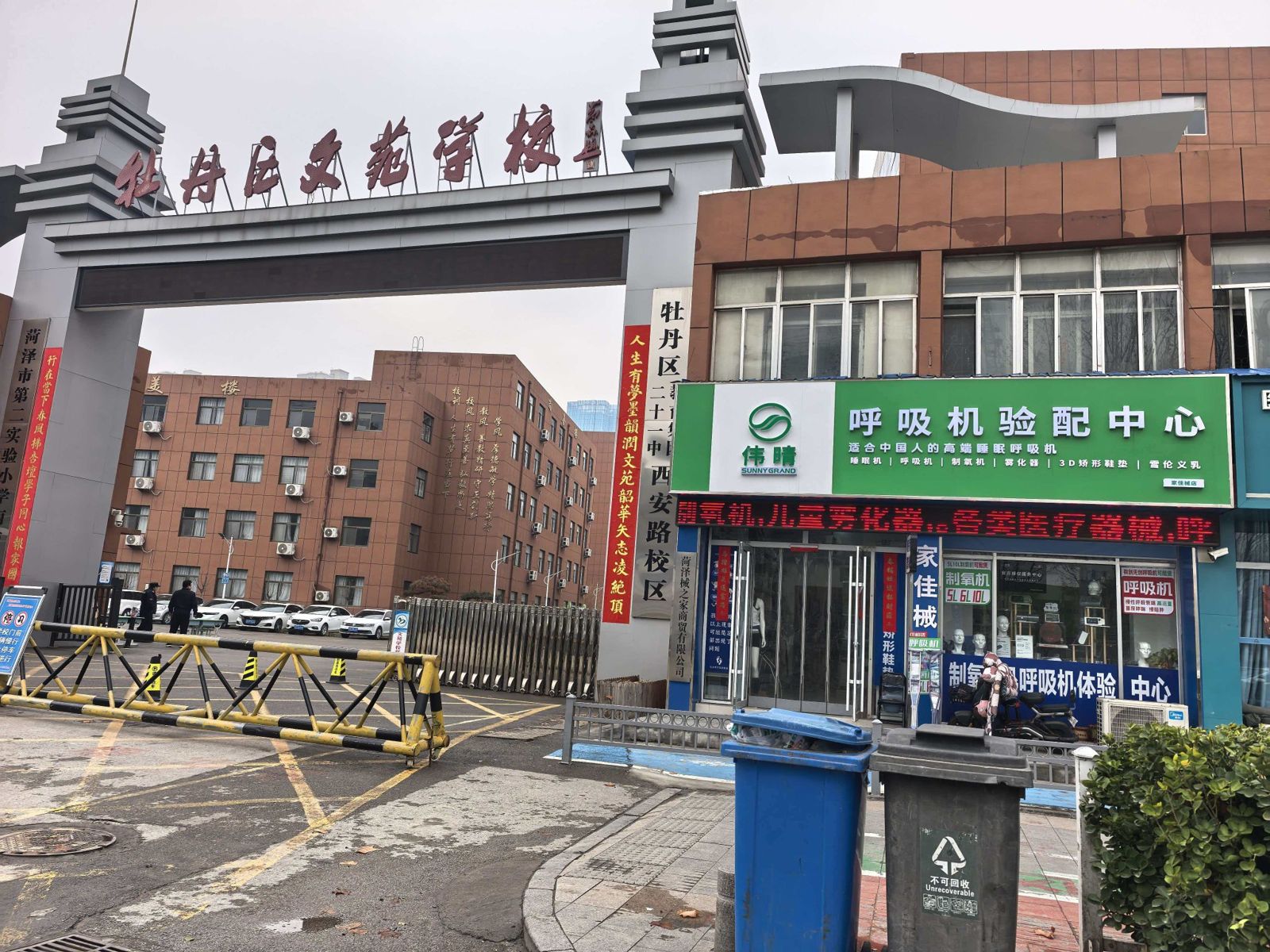 牡丹区文苑学校大门与北邻的菏泽伟晴呼吸机验配中心门店同框